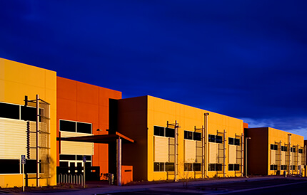 An industrial buildings having along the black city streets and with an orange and yellow exterior coatings with the use of the complete blasting facilities.